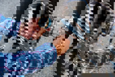 Close up of a man's hands checking his vehicle's tire pressure
