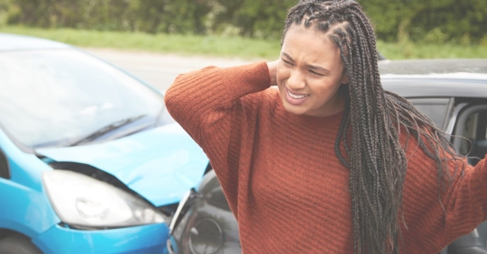 woman holding neck after car accident