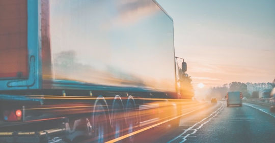 a tractor trailer speeding down a highway