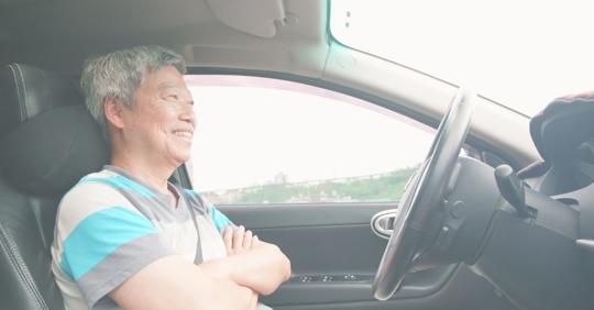 man with hands off steering wheel