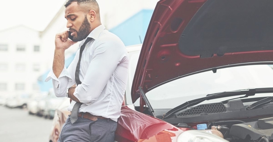man on phone next to car with hood up