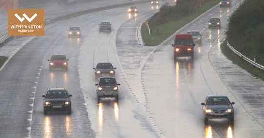 cars driving in the road while raining